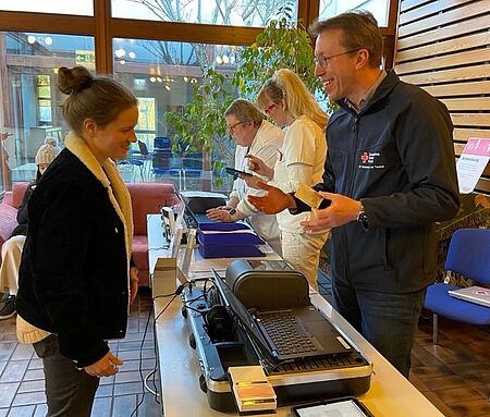 Ein DRK Helfer registriert eine Spenderin bei der Blutspende.